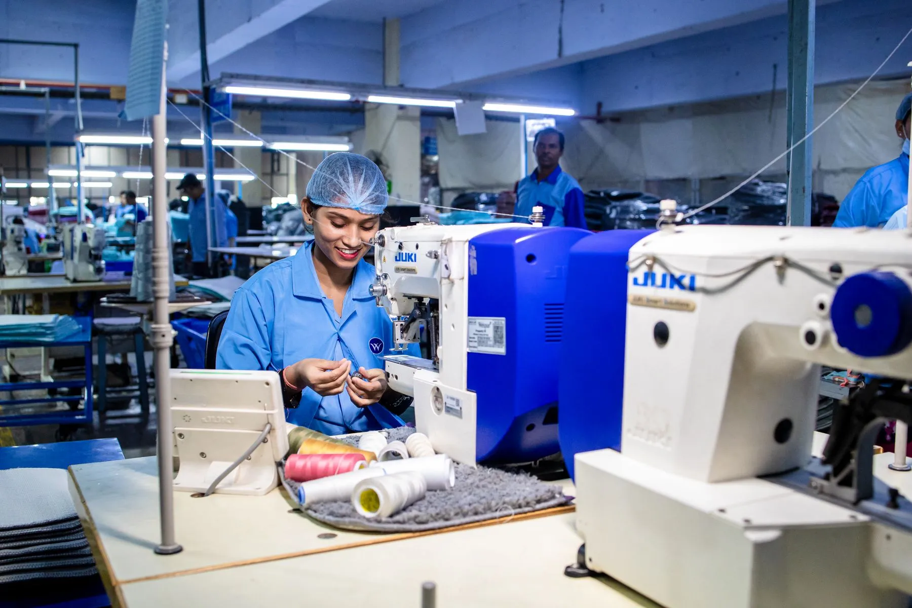 Operator menjahit di lini produksi garmen